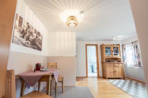 a dining room with a table and a kitchen at Ferienwohnung 12er in Sankt Gilgen