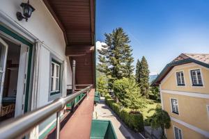 a balcony of a house with a view of a yard at Ferienwohnung 12er in Sankt Gilgen