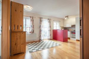 a kitchen with a red refrigerator and a checkered floor at Ferienwohnung 12er in Sankt Gilgen +4 photos