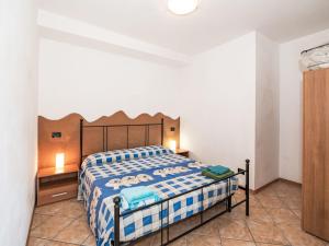 a bedroom with a bed with a blue and white blanket at Apartment Piersa by Interhome in Mergozzo +11 photos