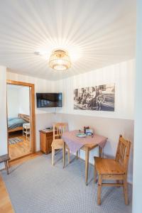 a living room with a table and chairs and a chandelier at Ferienwohnung 12er in Sankt Gilgen