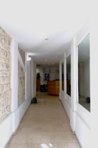 a hallway with white walls and a stone wall at Hipotel Paris Voltaire Bastille in Paris