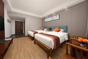 a hotel room with two beds with orange pillows at Lissen Hotel -5 min to Forest Park East Gate & Tour Tickets-Butler-recommended travel routes in Zhangjiajie +21 photos