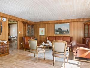 a living room with wood paneling and a table and chairs at Holiday Home Extorp by Interhome in Hamneda