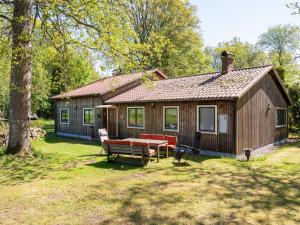 a small house with a picnic table in front of it at Holiday Home Extorp by Interhome in Hamneda