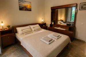 a bedroom with a large bed with towels on it at Nostalgia by the Sea in Agioi Theodoroi