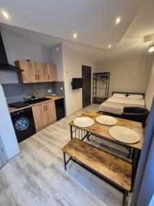 a room with a bed and a table and a kitchen at Willa "Aparthause" E-Apartamenty in Mielec