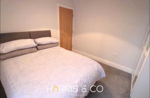 a bedroom with a white bed in a room at Fishermans View in Fleetwood