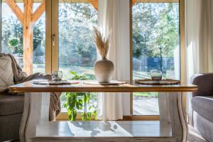a table with a vase on it in front of a window at Country house in Dziemiany