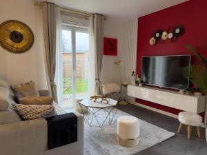 a living room with a large flat screen tv at Escale des Grimpeurs in Milly-la-Forêt