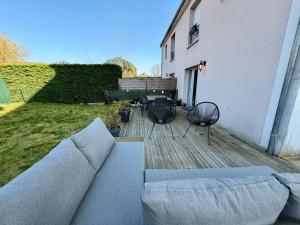 a couch and two chairs and a table on a deck at Escale des Grimpeurs in Milly-la-Forêt