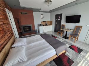 a bedroom with a large bed and a kitchen at Willa "Aparthause" E-Apartamenty in Mielec