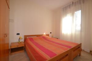 a bedroom with a bed and a window at Orchidea in Bibione