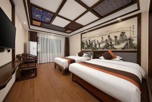 a hotel room with two beds and a tv at Lissen Hotel -5 min to Forest Park East Gate & Tour Tickets-Butler-recommended travel routes in Zhangjiajie