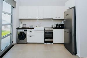 a kitchen with white cabinets and a stainless steel refrigerator at Breathtaking view guesthouse2 in Psalidi