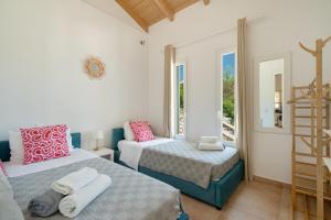 a bedroom with two beds and a window at Villa Olivia Panoramic Sea View in Lefkada +27 photos