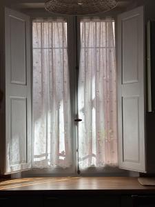 a window with white curtains in a room at Casa Virginia in Torrenieri