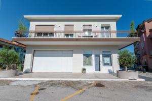 a white house with a balcony on top of it at In Riva in Cavallino-Treporti