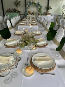 a long table with white tables and white chairs at Hacienda Guadalquivir in Córdoba