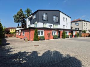 a building with a black roof on a street at Willa "Aparthause" E-Apartamenty in Mielec