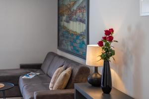 a living room with a couch and a vase with roses at CURICTA Design Apartments in Krk