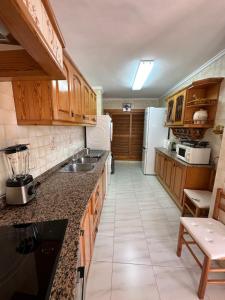 a kitchen with wooden cabinets and a white refrigerator at piso en puerto de Jávea in Jávea