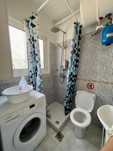 a bathroom with a washing machine and a toilet at Luxury suites XiangBaLa Glyfada in Athens +50 photos