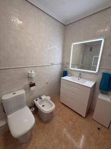 a bathroom with a toilet and a sink and a mirror at piso en puerto de Jávea in Jávea +12 photos
