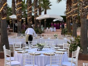 a table set up for a wedding with white tables and chairs at Hacienda Guadalquivir in Córdoba +80 photos