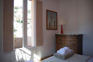 a bedroom with a bed with a dresser and a window at Casa Belladona Barcelona in Barcelona
