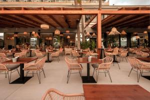 a restaurant with tables and chairs in a building at Caramelo Calvia Beach - Adults Only in Magaluf