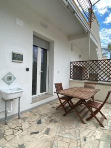 a patio with a wooden table and a sink at Orsa Maggiore apartment with private courtyard in Uggiano la Chiesa