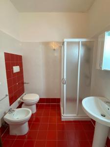 a bathroom with two toilets and a shower and a sink at Orsa Maggiore apartment with private courtyard in Uggiano la Chiesa
