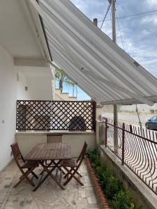a picnic table and two chairs under a canopy on a balcony at Orsa Maggiore apartment with private courtyard in Uggiano la Chiesa