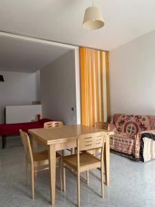 a living room with a table and chairs and a couch at Orsa Maggiore apartment with private courtyard in Uggiano la Chiesa