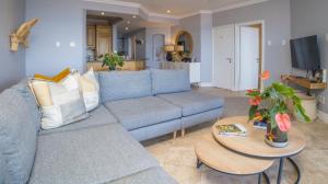 a living room with a blue couch and a table at 404 Oyster Rock - by Stay in Umhlanga in Durban
