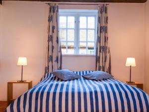 a bedroom with a bed with two pillows and a window at Ferienwohnung Blücherkate I - Boldevitzer Rügenkaten in Parchtitz