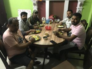 a group of men sitting around a table eating food at Konjyosom Homestay-Experience Real Nepali Hospitality in Kathmandu
