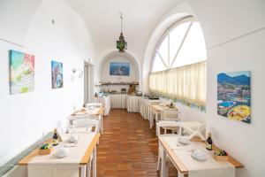 a restaurant with tables and chairs and a large window at Palatium Mari in Capri