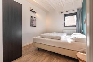a bedroom with a bed and a window at De Goudbalpeer - Ruim en luxe vakantiehuis voor 6 personen met uitzicht op wijngaard in Ruinerwold