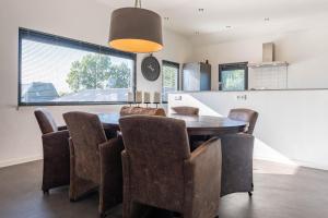 a dining room with a table and chairs at De Goudbalpeer - Ruim en luxe vakantiehuis voor 6 personen met uitzicht op wijngaard in Ruinerwold