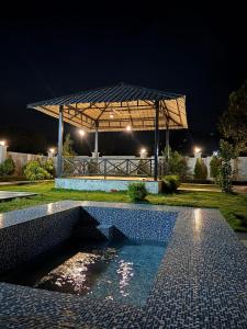 a swimming pool in front of a pavilion at night at Green Paradise 2BHK Villa with a Pool in Rishīkesh