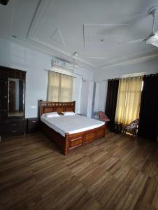 a bedroom with a large bed in a room with wooden floors at Green Paradise 2BHK Villa with a Pool in Rishīkesh