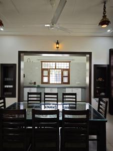 a dining room with a table and chairs and a window at Green Paradise 2BHK Villa with a Pool in Rishīkesh