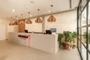 an office with a reception counter and pendant lights at Caramelo Calvia Beach - Adults Only in Magaluf +41 photos