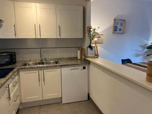 a kitchen with white cabinets and a sink at Breda 4a in Torroella de Montgrí