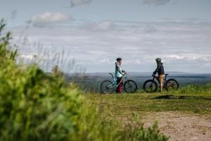 two people standing with bikes on a hill at Lapland Hotels Saaga in Ylläsjärvi