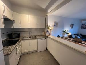 a kitchen with white cabinets and a sink at Breda 4a in Torroella de Montgrí