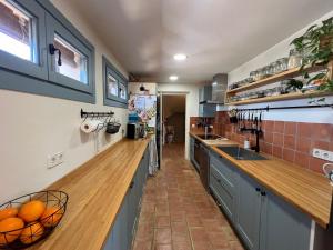 a kitchen with blue cabinets and a wooden counter top at Villa with privat pool La Bisbal in Vulpellach