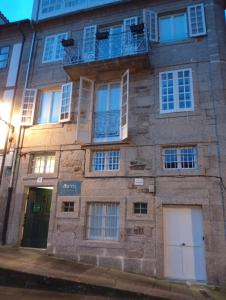 a brick building with a balcony on the side of it at Loureiros Dorm in Santiago de Compostela